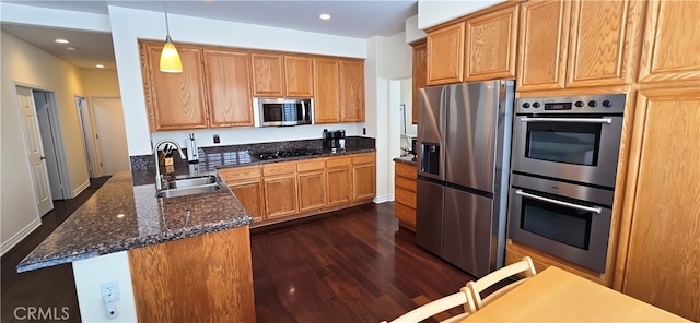 27324 Chesterfield Dr, Valencia, CA 91354 - kitchen with stainless steel appliances, a sink, dark wood-style flooring, dark stone counters, and hanging light fixtures