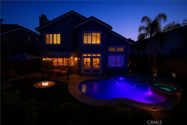 27324 Chesterfield Dr, Valencia, CA 91354 - rear view of house featuring an in-ground hot tub, a fire pit, a patio area, stucco siding, and a chimney