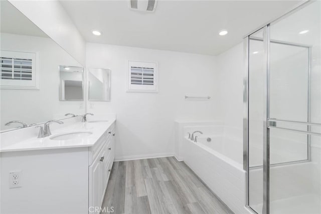 7453 Jersey St, Chino, CA 91708 - full bath featuring a garden tub, double vanity, wood finished floors, a stall shower, and recessed lighting