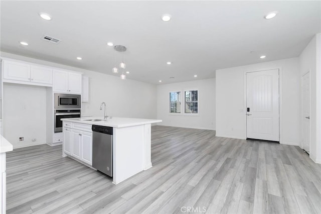 7453 Jersey St, Chino, CA 91708 - kitchen featuring appliances with stainless steel finishes, a sink, light wood-type flooring, white cabinets, and recessed lighting