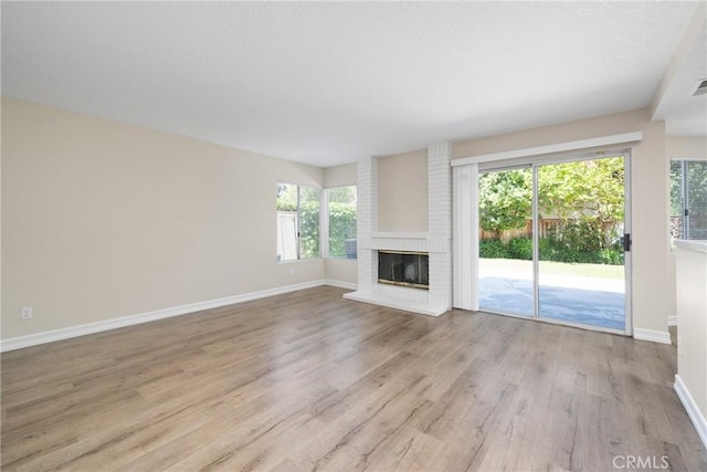 3 Andria, Irvine, CA 92614 - unfurnished living room featuring wood finished floors, baseboards, a fireplace, and plenty of natural light