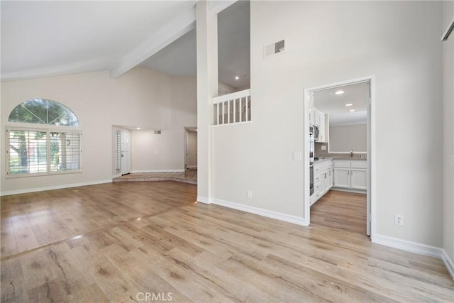3 Andria, Irvine, CA 92614 - unfurnished living room with high vaulted ceiling, light wood-style floors, beamed ceiling, and baseboards