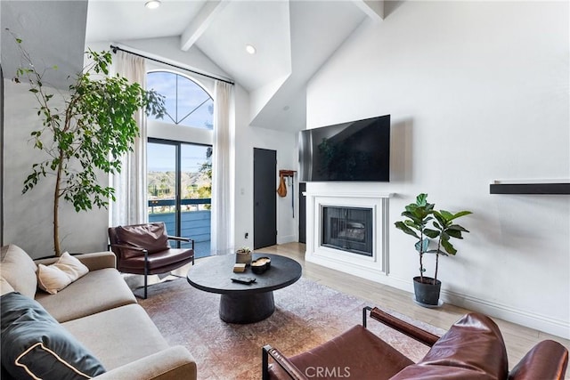 26873 Claudette St Unit 112, Canyon Country, CA 91351 - living room featuring high vaulted ceiling, beamed ceiling, wood finished floors, a glass covered fireplace, and baseboards