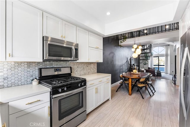 26873 Claudette St Unit 112, Canyon Country, CA 91351 - kitchen with appliances with stainless steel finishes, white cabinets, light countertops, light wood finished floors, and recessed lighting