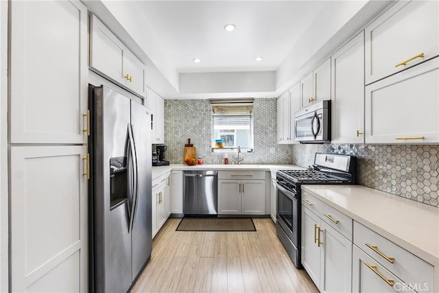 26873 Claudette St Unit 112, Canyon Country, CA 91351 - kitchen with stainless steel appliances, light wood-type flooring, light countertops, decorative backsplash, and recessed lighting