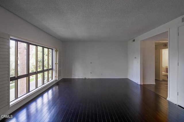 631 Wilcox Ave Unit 2E, Los Angeles, CA 90004 - empty room with dark wood finished floors, a textured ceiling, and baseboards