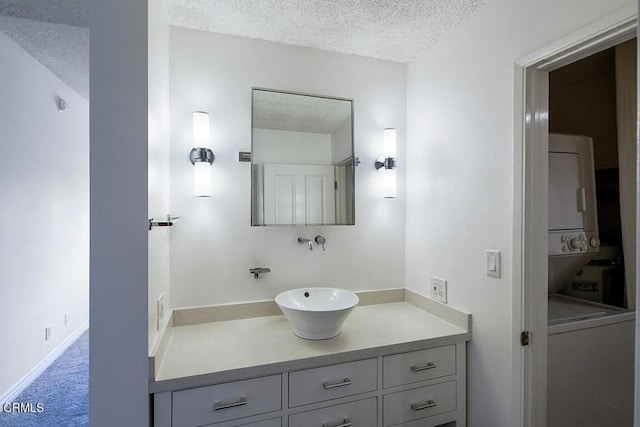 631 Wilcox Ave Unit 2E, Los Angeles, CA 90004 - bathroom with stacked washer / drying machine, a textured ceiling, and vanity