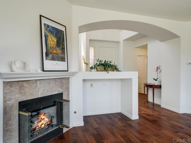 11615 Trailbrook Ln, San Diego, CA 92128 - living room featuring wood finished floors, a tiled fireplace, arched walkways, and baseboards