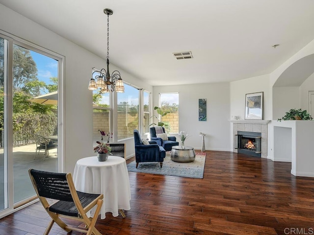 11615 Trailbrook Ln, San Diego, CA 92128 - dining space with wood-type flooring, a tile fireplace, a chandelier, arched walkways, and baseboards