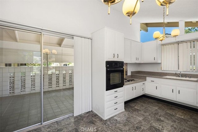 542 Via Estrada Unit A, Laguna Woods, CA 92637 - kitchen with oven, a sink, white cabinets, decorative light fixtures, and white cooktop