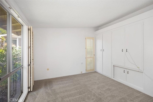 542 Via Estrada Unit A, Laguna Woods, CA 92637 - unfurnished bedroom with carpet floors and a textured ceiling