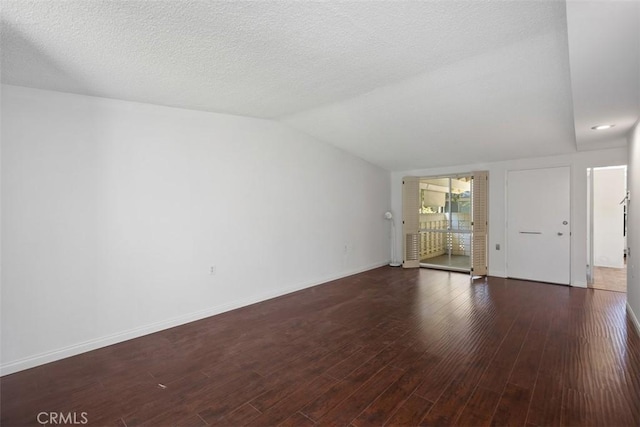 542 Via Estrada Unit A, Laguna Woods, CA 92637 - unfurnished living room featuring lofted ceiling, baseboards, and wood finished floors