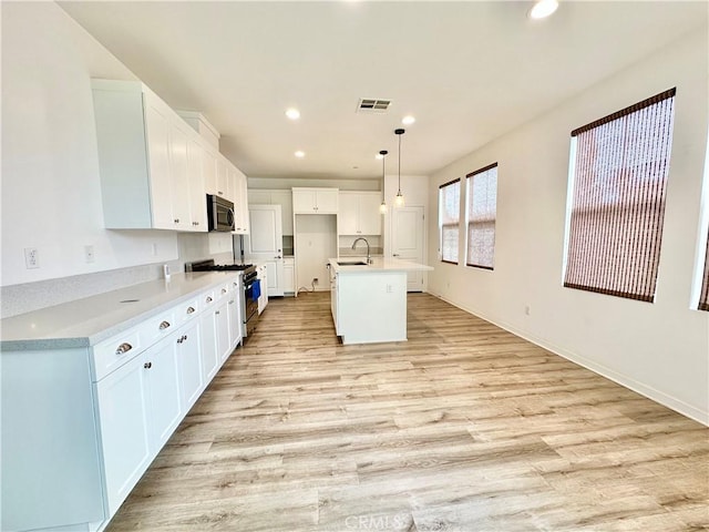 403 Aura Dr, Costa Mesa, CA 92626 - kitchen featuring appliances with stainless steel finishes, light wood finished floors, recessed lighting, white cabinets, and light countertops