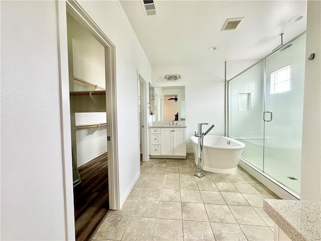 403 Aura Dr, Costa Mesa, CA 92626 - bathroom featuring a shower stall, a spacious closet, vanity, a freestanding bath, and tile patterned flooring