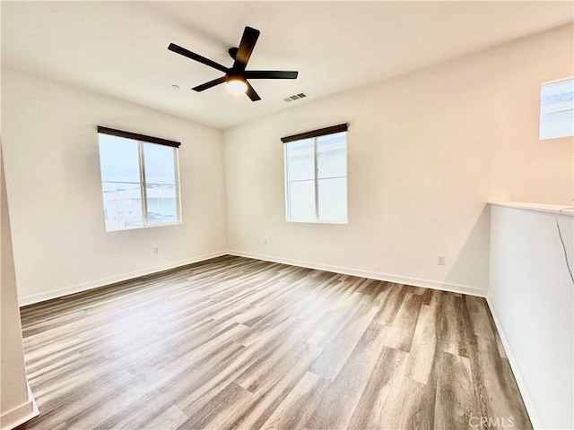403 Aura Dr, Costa Mesa, CA 92626 - empty room with wood finished floors, plenty of natural light, and baseboards