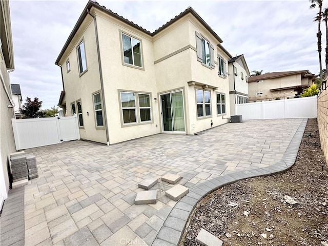 403 Aura Dr, Costa Mesa, CA 92626 - rear view of property with a patio area, stucco siding, a fenced backyard, and central AC