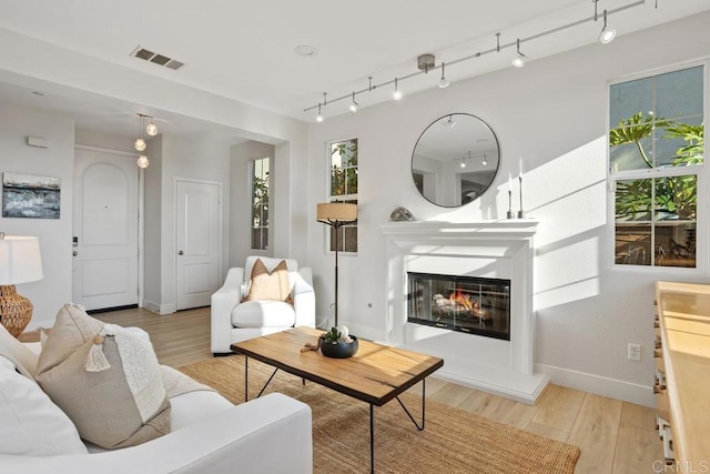 2386 Lapis Rd, Carlsbad, CA 92009 - living room with light wood-type flooring, baseboards, plenty of natural light, and a glass covered fireplace