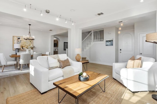 2386 Lapis Rd, Carlsbad, CA 92009 - living area featuring light wood-style flooring, arched walkways, stairs, and baseboards
