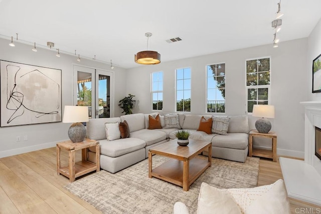 2386 Lapis Rd, Carlsbad, CA 92009 - living area featuring track lighting, light wood finished floors, baseboards, and a glass covered fireplace