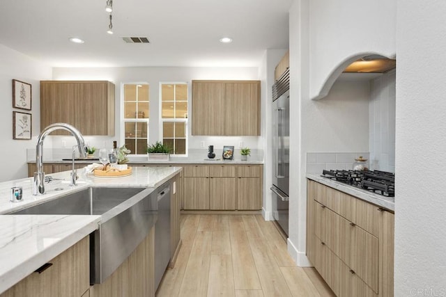 2386 Lapis Rd, Carlsbad, CA 92009 - kitchen featuring appliances with stainless steel finishes, a sink, modern cabinets, light stone counters, and recessed lighting
