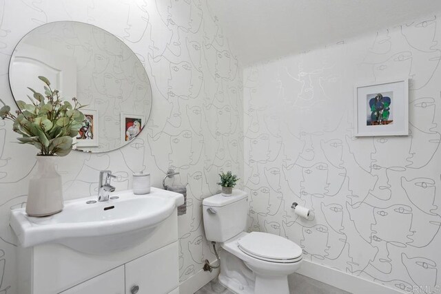 2386 Lapis Rd, Carlsbad, CA 92009 - half bathroom featuring wallpapered walls, toilet, and vanity