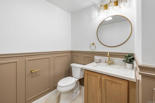 1711 Alhudson Dr, Escondido, CA 92029 - bathroom with vanity, toilet, a wainscoted wall, and a decorative wall