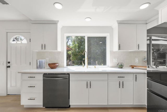 1711 Alhudson Dr, Escondido, CA 92029 - kitchen featuring stainless steel dishwasher, a sink, white cabinetry, light countertops, and backsplash