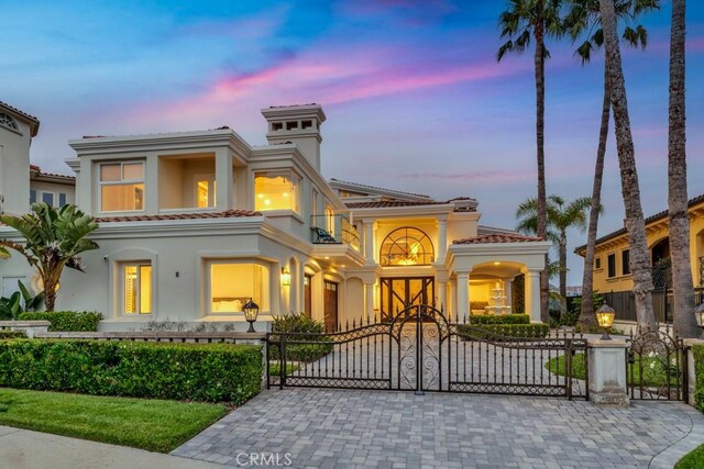 8 Saint Tropez, Laguna Niguel, CA 92677 - mediterranean / spanish house featuring a gate, a tile roof, a fenced front yard, and a balcony
