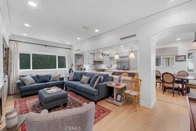 8 Saint Tropez, Laguna Niguel, CA 92677 - living room featuring ornamental molding, arched walkways, light wood finished floors, and recessed lighting