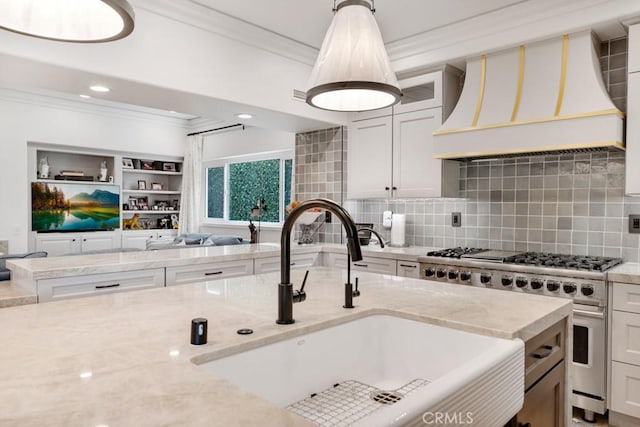 8 Saint Tropez, Laguna Niguel, CA 92677 - kitchen featuring high end range, ornamental molding, a sink, custom exhaust hood, and open floor plan
