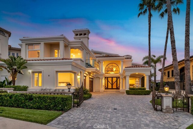 8 Saint Tropez, Laguna Niguel, CA 92677 - mediterranean / spanish-style home featuring a balcony, a tiled roof, decorative driveway, stucco siding, and a gate