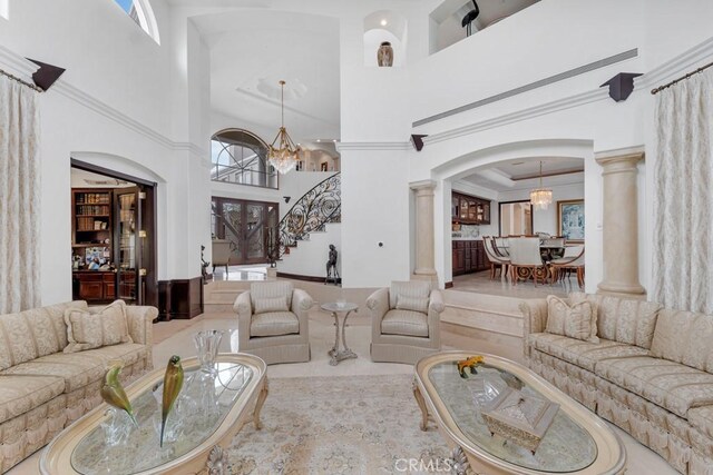 8 Saint Tropez, Laguna Niguel, CA 92677 - living area featuring decorative columns, a towering ceiling, arched walkways, a chandelier, and crown molding