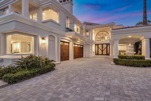 8 Saint Tropez, Laguna Niguel, CA 92677 - property entrance with an attached garage, decorative driveway, a balcony, and stucco siding