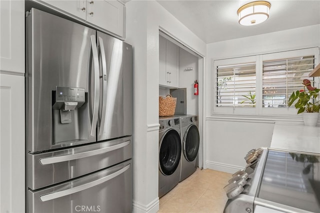 700 Esplanade Unit 9, Redondo Beach, CA 90277 - laundry room featuring washing machine and clothes dryer, baseboards, light tile patterned floors, and cabinet space
