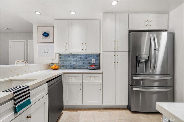 700 Esplanade Unit 9, Redondo Beach, CA 90277 - kitchen featuring stainless steel appliances, white cabinetry, light tile patterned flooring, backsplash, and light stone countertops