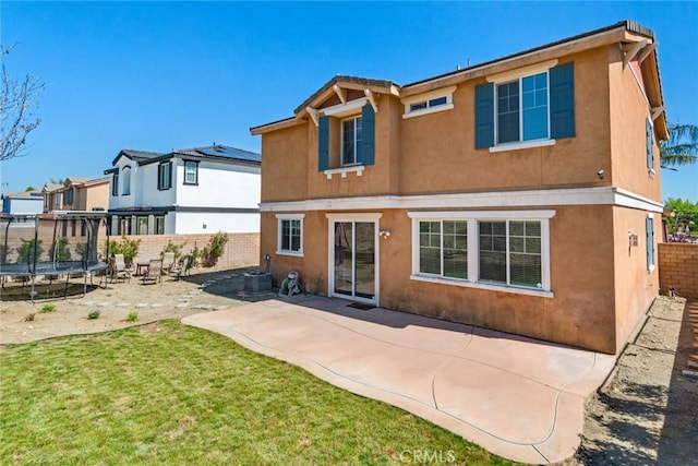 15190 Fox Ridge Dr, Fontana, CA 92336 - rear view of house with a trampoline, stucco siding, and a patio area