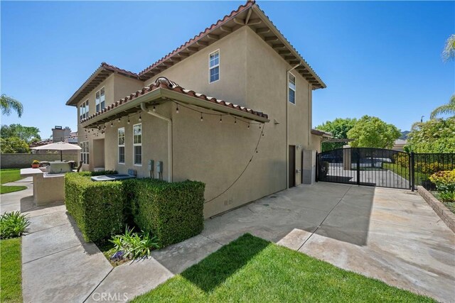 26865 Grey Pl, Stevenson Ranch, CA 91381 - view of home's exterior featuring a gate, stucco siding, and a tile roof