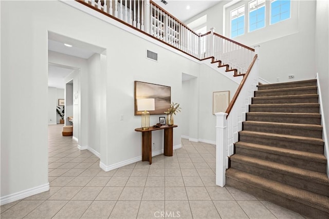 26865 Grey Pl, Stevenson Ranch, CA 91381 - staircase featuring tile patterned floors, a high ceiling, and baseboards