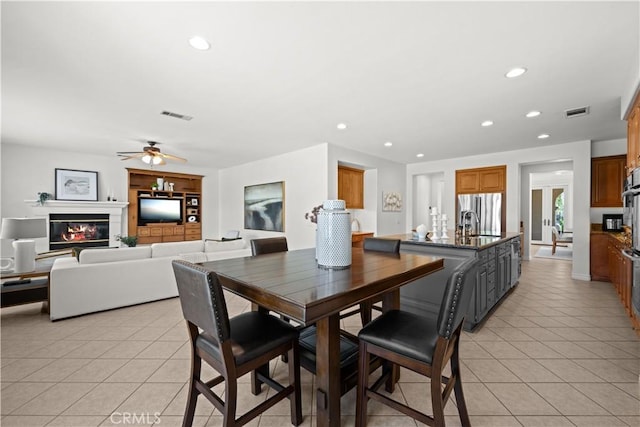 26865 Grey Pl, Stevenson Ranch, CA 91381 - dining room with light tile patterned floors, recessed lighting, ceiling fan, and a glass covered fireplace