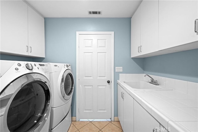 26865 Grey Pl, Stevenson Ranch, CA 91381 - laundry room featuring washing machine and clothes dryer, cabinet space, and light tile patterned floors