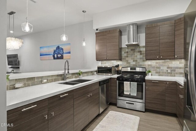 3236 Royal Oaks Dr Unit 5, Thousand Oaks, CA 91362 - kitchen with appliances with stainless steel finishes, wall chimney range hood, tasteful backsplash, light countertops, and light wood-style floors
