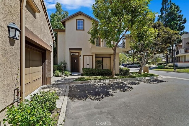 7 Montara Dr, Aliso Viejo, CA 92656 - view of front of house with stucco siding, a balcony, driveway, and an attached garage