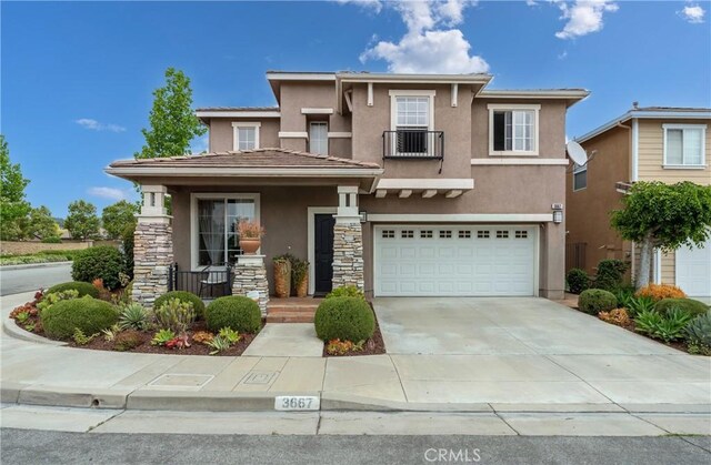 3667 Hawks Dr, Brea, CA 92823 - view of front of house featuring stucco siding, stone siding, a garage, driveway, and covered porch