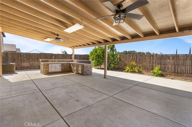 522 Sansoni St, Los Banos, CA 93635 - fenced backyard with a ceiling fan, an outdoor kitchen, central AC unit, and a patio area