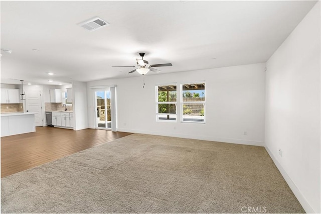 522 Sansoni St, Los Banos, CA 93635 - unfurnished living room with carpet flooring, baseboards, a sink, and recessed lighting