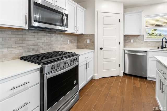 522 Sansoni St, Los Banos, CA 93635 - kitchen with appliances with stainless steel finishes, a sink, dark wood-style floors, light countertops, and white cabinets