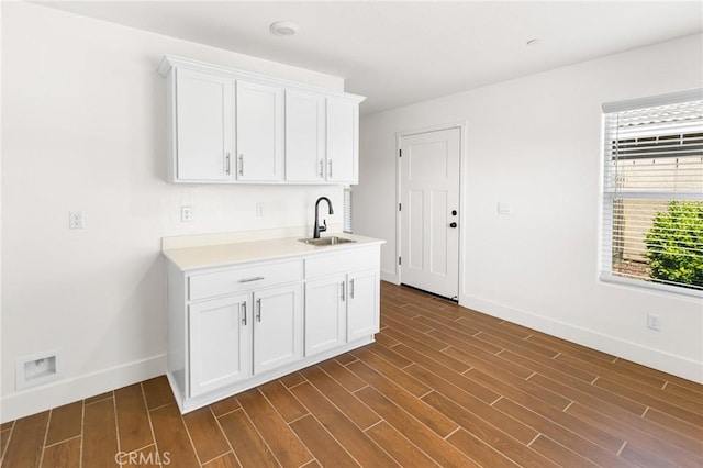 522 Sansoni St, Los Banos, CA 93635 - kitchen featuring baseboards, a sink, light countertops, and white cabinets