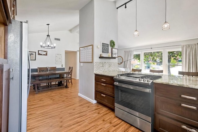 1807 Calle Sinaloa, Vista, CA 92084 - kitchen featuring gas stove, a chandelier, freestanding refrigerator, light wood-type flooring, and light stone countertops