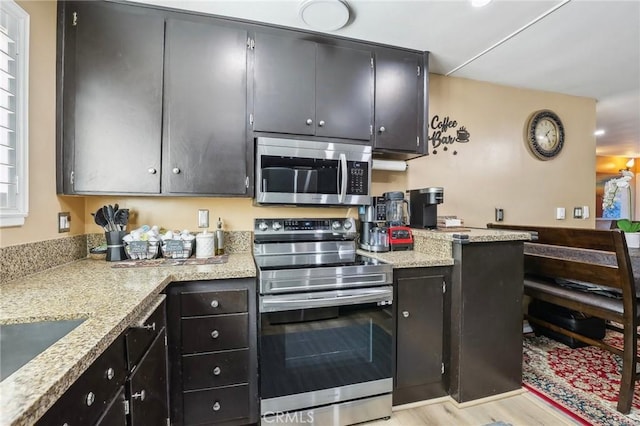 3110 Merrill Dr Unit 67, Torrance, CA 90503 - kitchen with appliances with stainless steel finishes, dark cabinetry, light wood finished floors, and a sink
