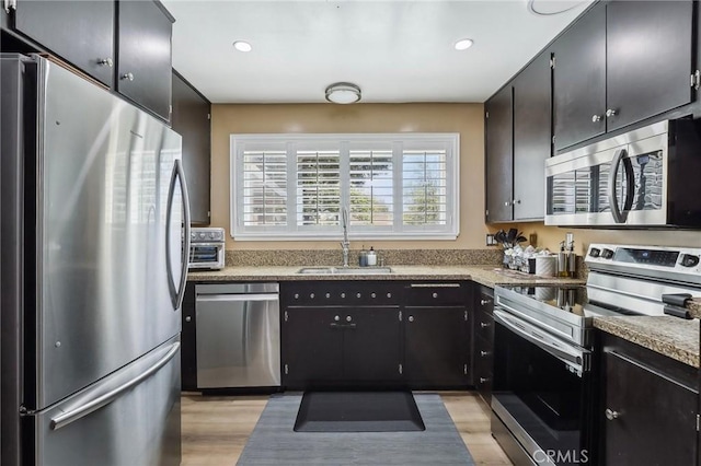3110 Merrill Dr Unit 67, Torrance, CA 90503 - kitchen with appliances with stainless steel finishes, a sink, light wood-style floors, recessed lighting, and dark cabinetry
